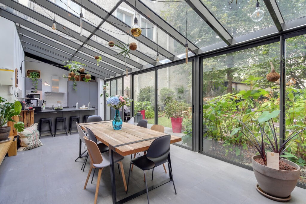 Maison moderne avec verrière, salle à manger lumineuse avec vue sur jardin